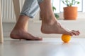 Man massaging arthritic feet with ball at home