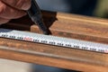 Man master builder measures metal with a working measuring tool, tape measure and marker in the hands of a worker Royalty Free Stock Photo