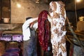 Man master paints Eastern, Turkish silk women`s scarves, shawls in a barrel of paint, texture, background, pattern