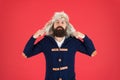 Man mature bearded stand warm jumper and hat on red background. Winter season menswear. Hipster rustic style outfit