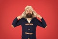 Man mature bearded stand warm jumper and hat on red background. Winter season menswear. Hipster rustic style outfit