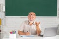 Man mature teacher. Portrait of happy senior tutor in glasses with book on the blackboard in class at high school or Royalty Free Stock Photo