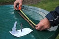 Man measures metal rod length with roulette.