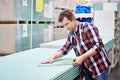 Man measures with roulette drywall sheets in store building mate Royalty Free Stock Photo