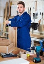 Man measuring boards for furniture at workshop