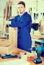 Man measuring boards for furniture at workshop