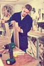 Man measuring boards for furniture at workshop