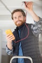 man measuring and cheking power supply voltage with digital multimeter Royalty Free Stock Photo