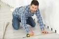 man measuring floor board