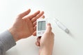 Man measuring glucose level with digital glucometer, closeup. Diabetes control