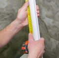 Man is measuring gypsum baseboard. Maintenance repair works renovation in the flat. Drywall panel