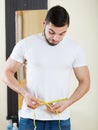 Man measuring his bicep and body Royalty Free Stock Photo