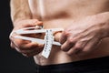 Man is measuring his body fat with calipers. Royalty Free Stock Photo