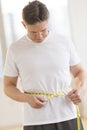 Man Measuring His Waist At Health Club Royalty Free Stock Photo