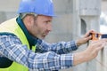 man measuring wall with construction level