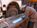 a man is measuring wooden logs for truck repairing purpose at automobile shop in india dec 2019 Royalty Free Stock Photo