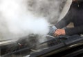 Man mechanic repair a smoking engine of his overheated car Royalty Free Stock Photo