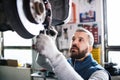 Man mechanic repairing a car in a garage. Royalty Free Stock Photo