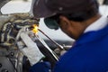 Man mechanical worker repairing a car body in a garage - Safety at work with protection wear. Welding work