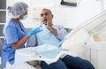 Man in chair complains of toothache to dentist