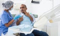 Man in chair complains of toothache to dentist