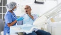 Man in chair complains of toothache to dentist