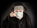 Man in medical face mask pointing finger on black background Royalty Free Stock Photo