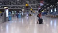 Man in medical Face Mask Walks with Suitcase in empty Airport. COVID-19 Coronavirus Pandemic Travel Restrictions