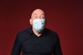 Man with medical mask expresion surprise on red background