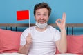 Man with medical mask holding small empty flag celebrating the end of quarantine