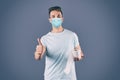 Man in medical mask holding toilet paper roll on background Royalty Free Stock Photo