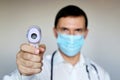 Man in medical mask measures body temperature, coronavirus symptoms Royalty Free Stock Photo