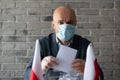 Man in medical mask putting his vote to voting ballot box.