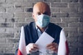 Man in medical mask putting his vote to voting ballot box.