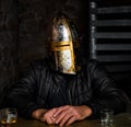 A man in a medieval iron knight`s helmet