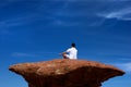 A man meditating on a high rock