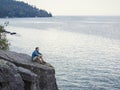 Man meditating and praying on cliff edge overlooking ocean Royalty Free Stock Photo