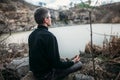 Man meditating on rocky cliff with river view Royalty Free Stock Photo