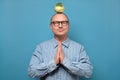 Man meditating staying calm in self quarantine holding green kohlrabi on head