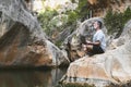 Man meditating on top of a rock at the foot of a mountain river Royalty Free Stock Photo