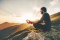 Man meditating yoga lotus pose at sunset mountains