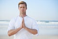 Man, meditation on beach and prayer for zen, wellness and holistic healing outdoor for calm and yoga. Ocean, fresh air Royalty Free Stock Photo