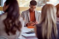 Man on meeting looking at mobil phone