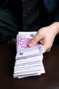 Man in Men's Suits.Bribe and corruption with euro banknotes. Man holding a lot of cash