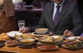 Man with menu in a restaurant taking order at table Royalty Free Stock Photo