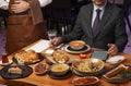 Man with menu in a restaurant taking order at table Royalty Free Stock Photo