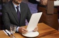 Man with menu in a restaurant taking order at table Royalty Free Stock Photo