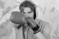 Man with messy hair on colorful background, selective focus. Boxer with confident face trains to punch. Sports and fight