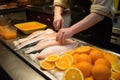 man meticulously placing orange slices onto fish fillets Royalty Free Stock Photo