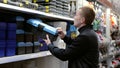 Man carefully choosing toolbox at hardware store, focusing on diy project. Shows handyman spirit in action. A man in a Royalty Free Stock Photo